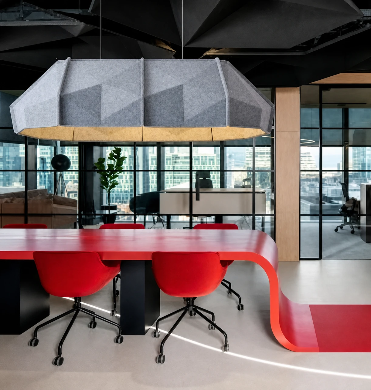 Faceted acoustic pendant lighting above an office meeting table