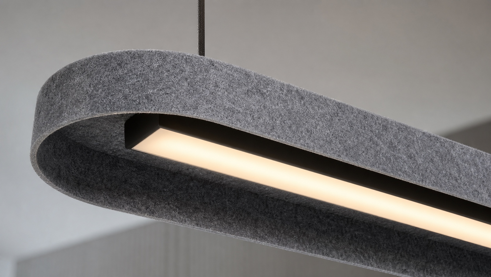 Close-up of a grey PET felt acoustic light showing its fibrous surface, cut edge and integrated LED